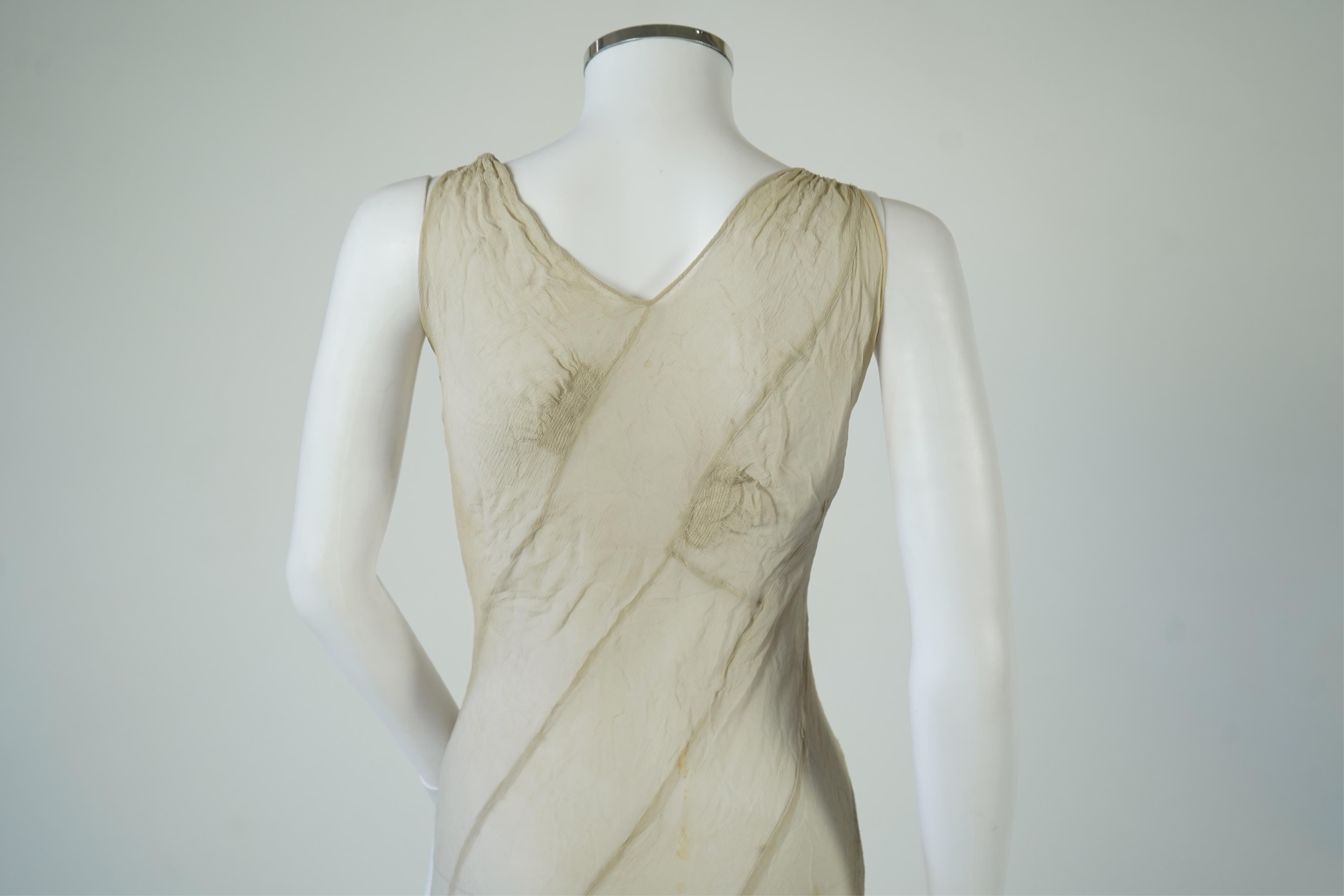 A 1930's grey chiffon bias cut ladies evening dress. 120cm long. Condition - has a small hole at the back and a light mark possibly removed with washing.